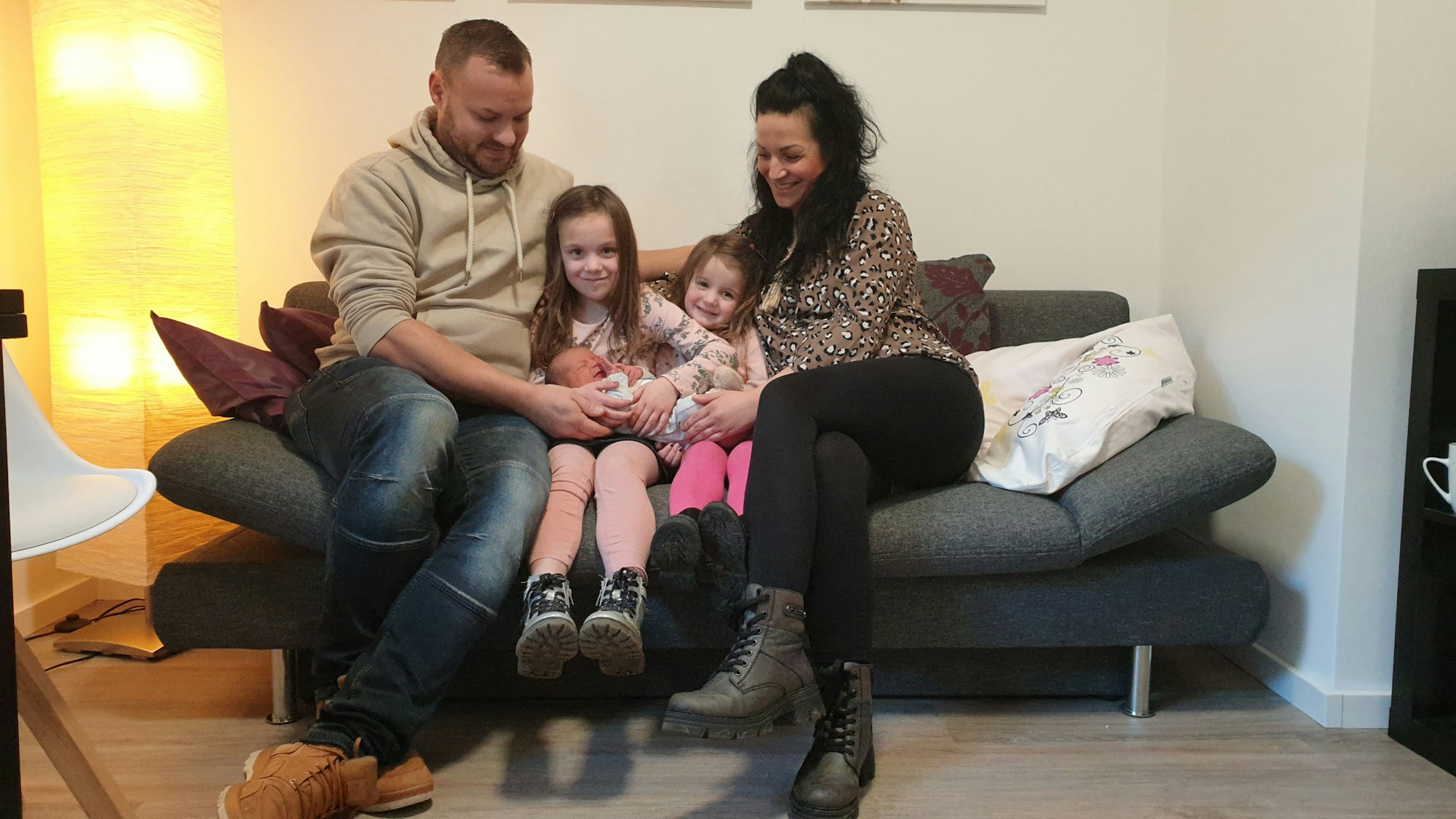 Das Euskirchener Neujahrsbaby Thilo Liam Okon im Arm seiner Familie: David Okon (l.), Susanne Okon mit den Kindern Lilli Alisa und Anni Mailin auf ihrer Couch.