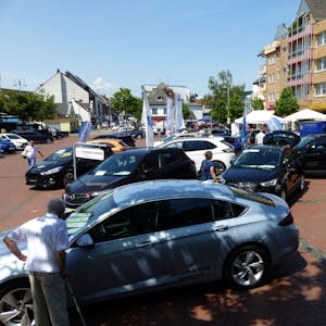 Mehrere Autos stehen auf dem Marktplatz in Pulheim bei einer Autoschau.