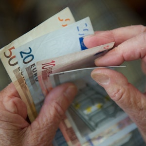 Eine ältere Person hält verschiedene Geldscheine in den Händen. Zu sehen sind 50, 20, zehn und fünf Euro-Scheine.