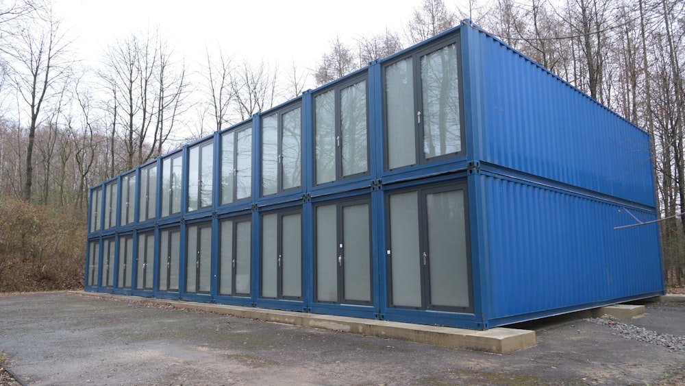 20 blaue Container mit doppelten Eingangstüren sind zu einem Block gestapelt in Odenthal-Odenau