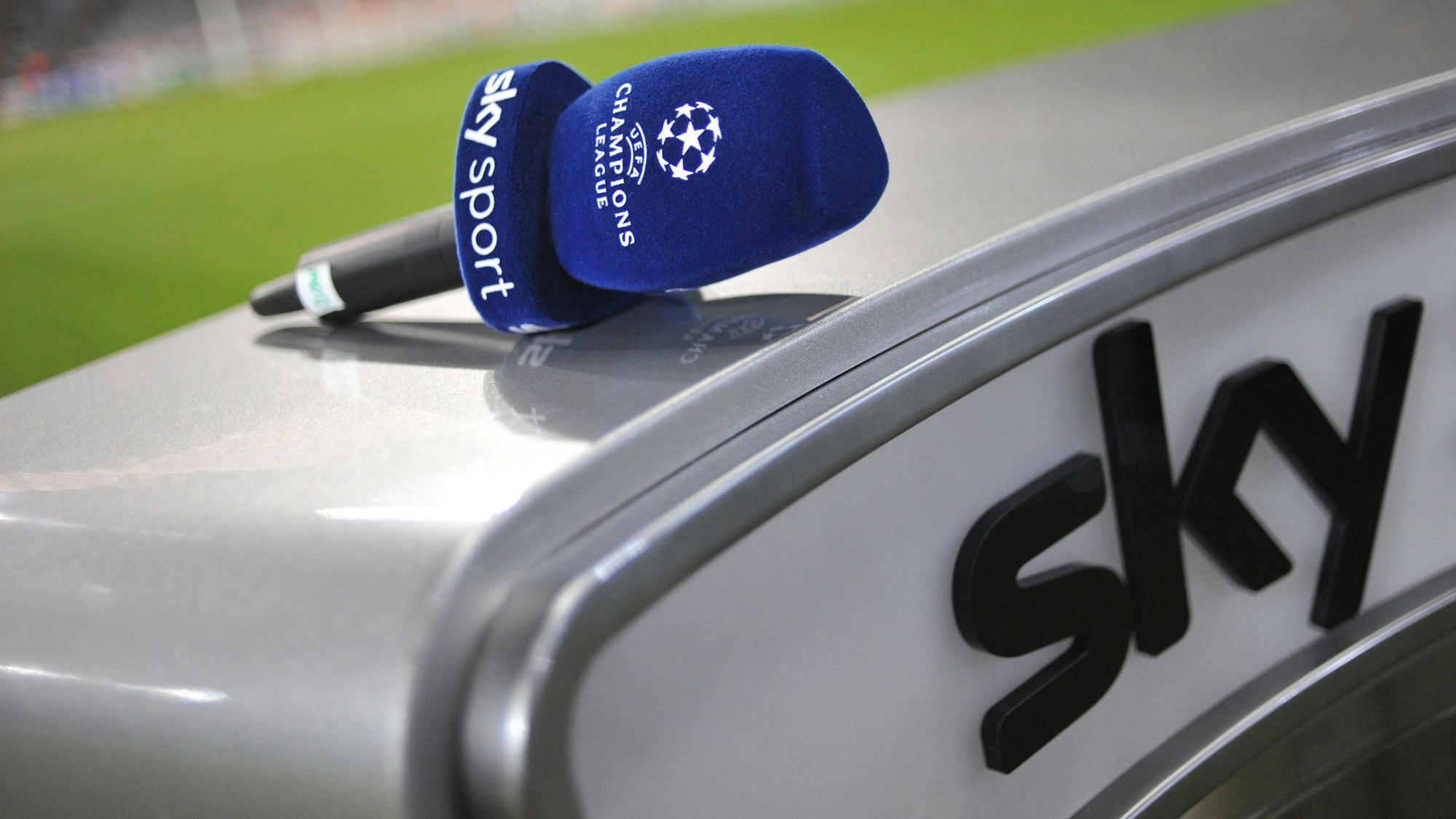 In einem Stadion liegt ein Mikrofon mit der Aufschrift „Sky Sport - Champions League“ auf einem Moderatoren-Pult des Pay-TV-Senders Sky.