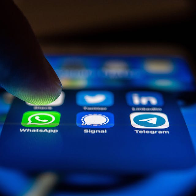 Auf einem Smartphone-Bildschirm sind nebeneinander die App-Icons von WhatsApp, Signal und Telegram zu sehen.
