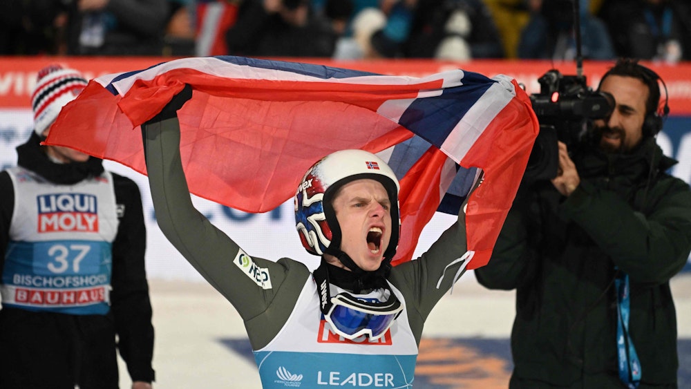 Norway's Halvor Egner Granerud celebrates with the Norwegian flag after winning the Four-Hills FIS Ski Jumping tournament (Vierschanzentournee), in Bischofshofen, Austria, on January 6, 2023. (Photo by CHRISTOF STACHE / AFP)