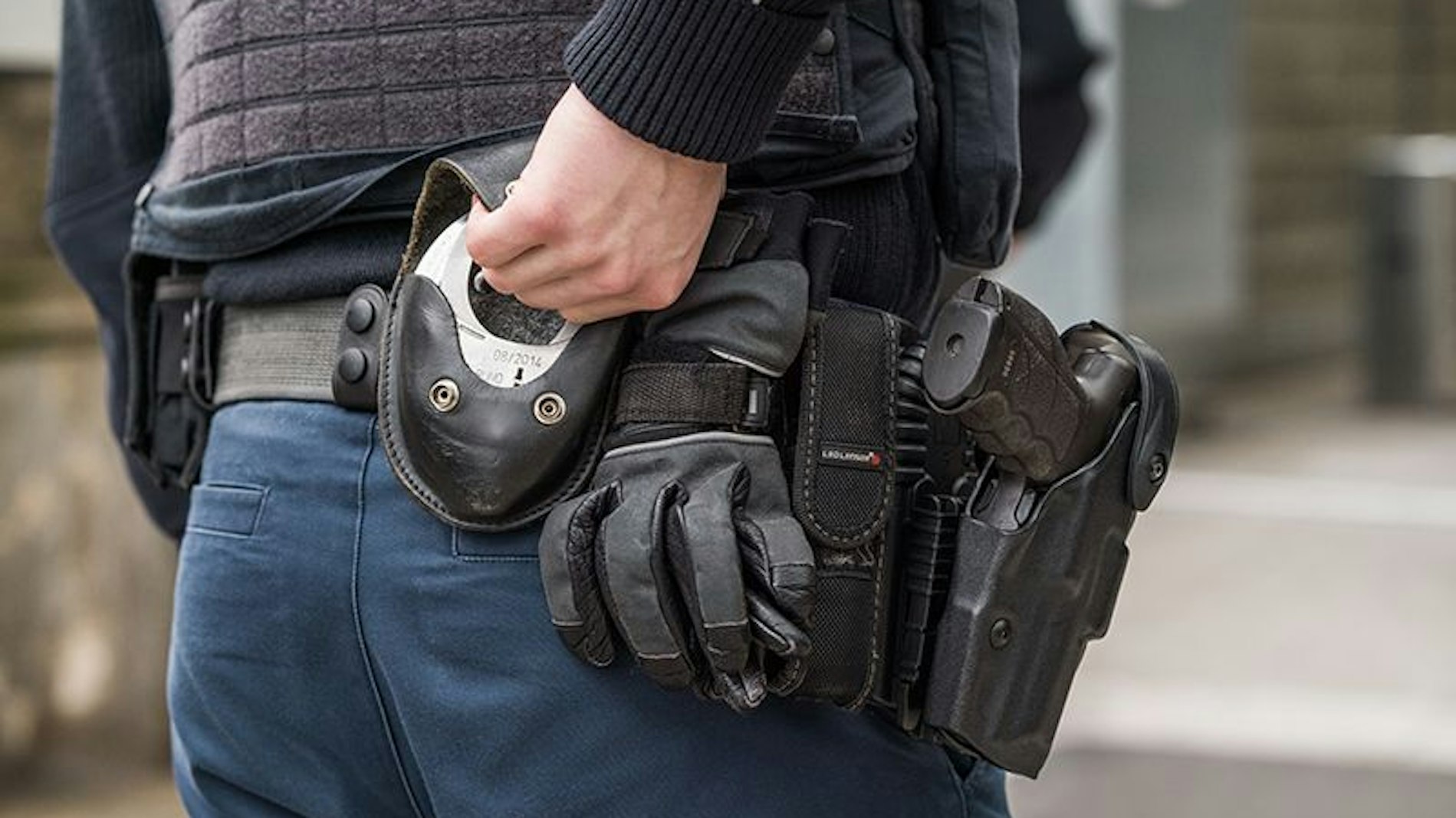 Ein Beamter der Bundespolizei greift zu seinen Handschellen