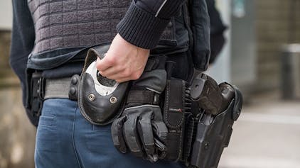 Ein Beamter der Bundespolizei greift zu seinen Handschellen