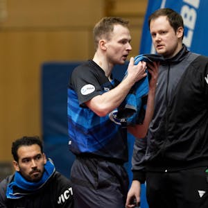 Schwalbe-Trainer Frederick Duda und sein Bruder und Spitzenspieler Benedikt Duda stehen in einer Sporthalle nebeneinander.
