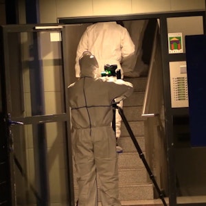 Mitarbeiter der Spurensicherung gehen in das Treppenhaus des Tathauses. Eine 52-jährige Frau ist in Berlin tot in ihrer Wohnung aufgefunden worden.