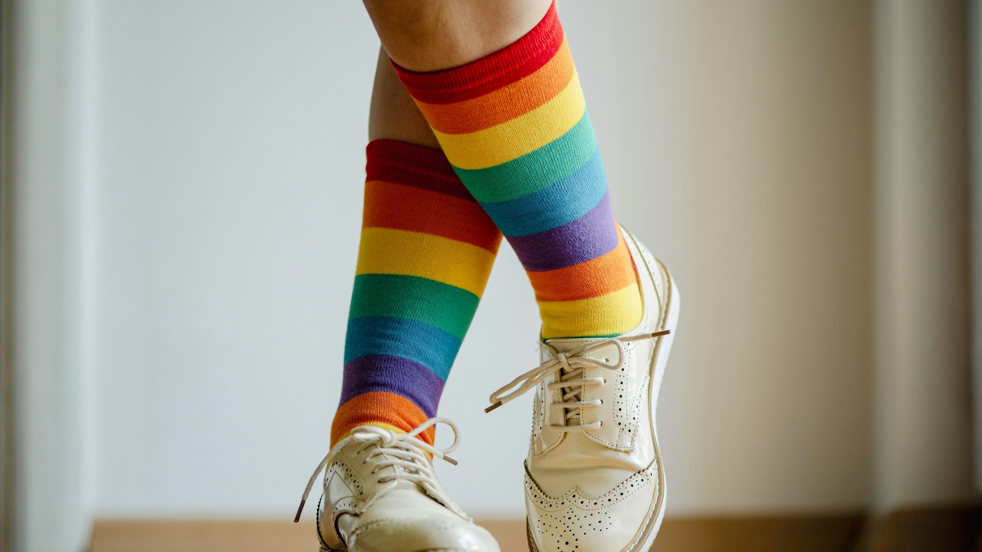 Beine einer Frau mit Socken in Regenbogenfarben