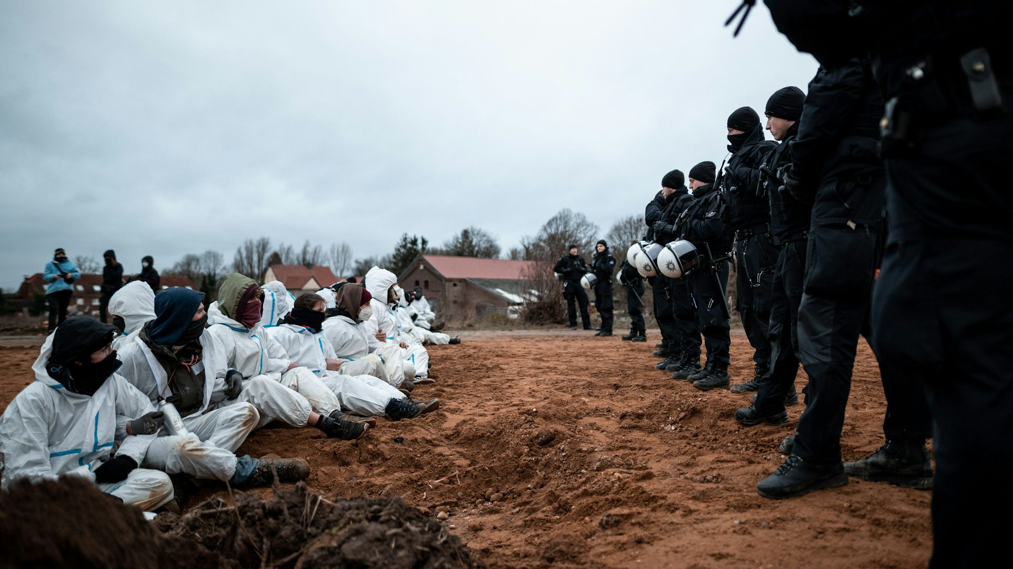 Erkelenz: Polizisten beobachten eine Blockade durch Umweltaktivisten vor dem Braunkohletagebau in Lützerath.