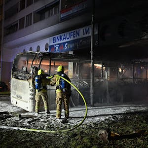 Feuerwehrmänner löschen an der Berliner Sonnenallee in der Silvesternacht einen Reisebus, der von Unbekannten angezündet worden war. Die Ausschreitungen in Berlin haben eine Debatte ausgelöst.