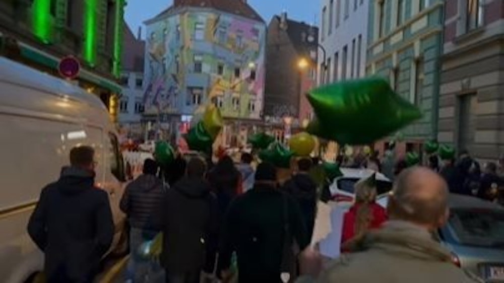 Fans ziehen mit grünen Luftballons durch Köln und feiern die Kölner Gaststätte Oma Kleinmann mit einer besonderen Aktion zum 20. Geburtstag.