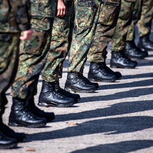 Soldaten der Bundeswehr stehen auf dem Appellplatz. Zu sehen sind nur die Hosen und Stiefel der Soldaten.