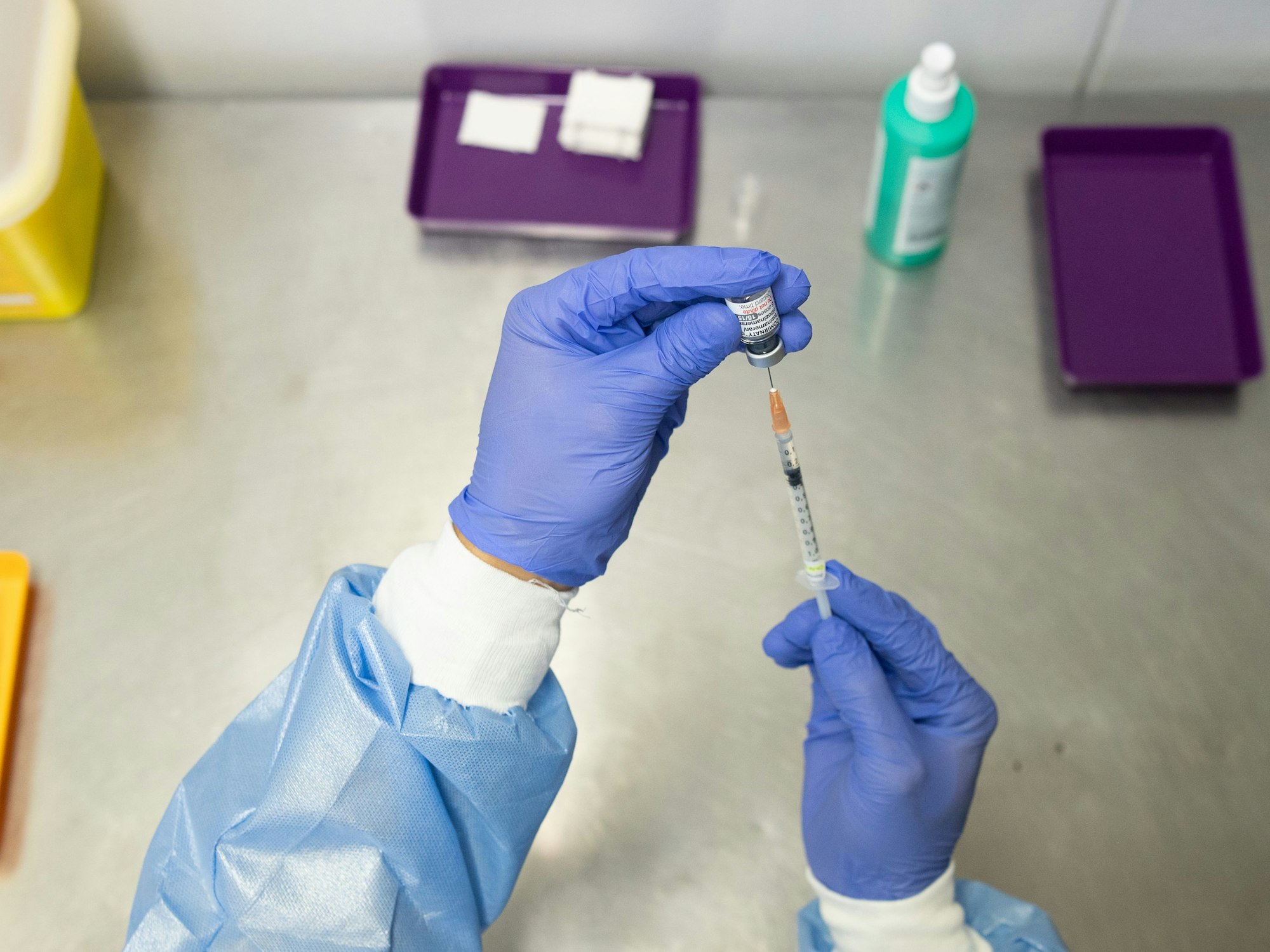 Ein Mitarbeiter zieht im Impfzentrum Mainz eine Spritze mit dem an die Omikron-BA.1-Variante angepassten Impfstoff Comirnaty von Biontech und Pfizer auf.