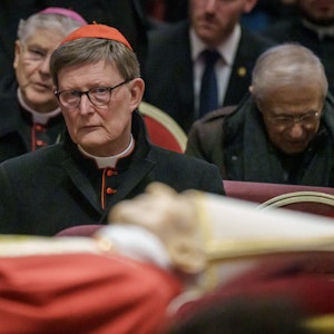 Kardinal Rainer Maria Woelki sitzt hinter dem Leichnam des verstorbenen Papstes Benedikt XVI., der im Petersdom aufgebahrt ist.
