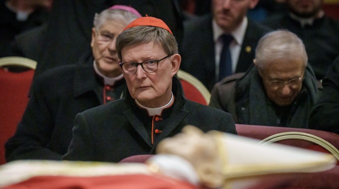 Kardinal Rainer Maria Woelki sitzt hinter dem Leichnam des verstorbenen Papstes Benedikt XVI., der im Petersdom aufgebahrt ist.