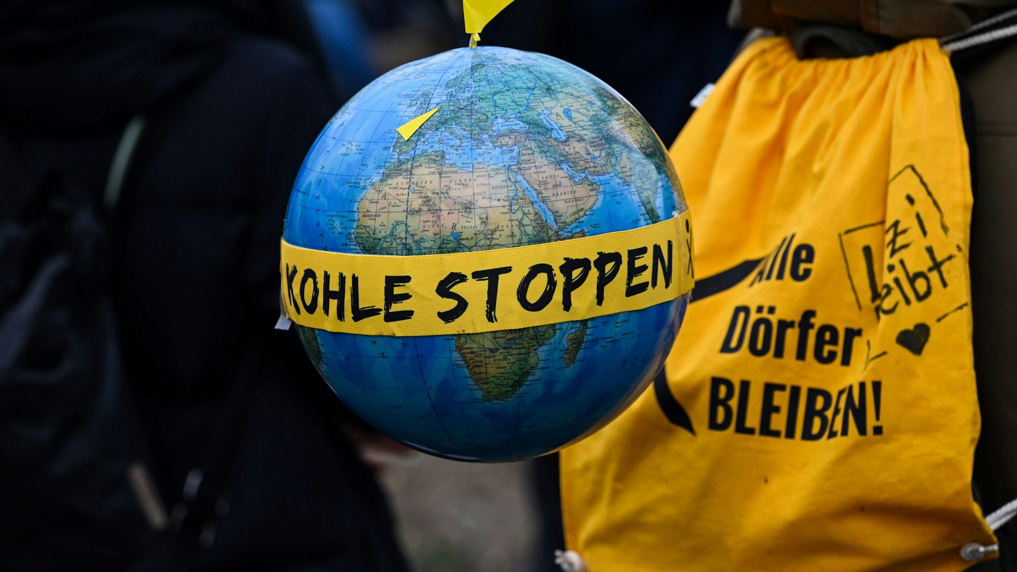 Ein Globus mit einem Fähnchen mit dem Ortsnamen "Lützerath" und dem Schriftzug "Kohle stoppen".