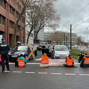 Aktivistinnen und Aktivisten der „Letzten Generation“ blockieren am Freitagmittag mit einer Sitzblockade die Cäcilienstraße, eine der zentralen Verkehrsachsen in der Kölner Innenstadt.&nbsp;