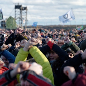 Teilnehmer einer Kundgebung am Rand des Tagebaus in der Nähe von Lützerath kreuzen als zeichen des Widerstandes ihre Arme. Lützerath soll zur Erweiterung des Braunkohletagebaus Garzweiler II abgebaggert werden. +++ dpa-Bildfunk +++