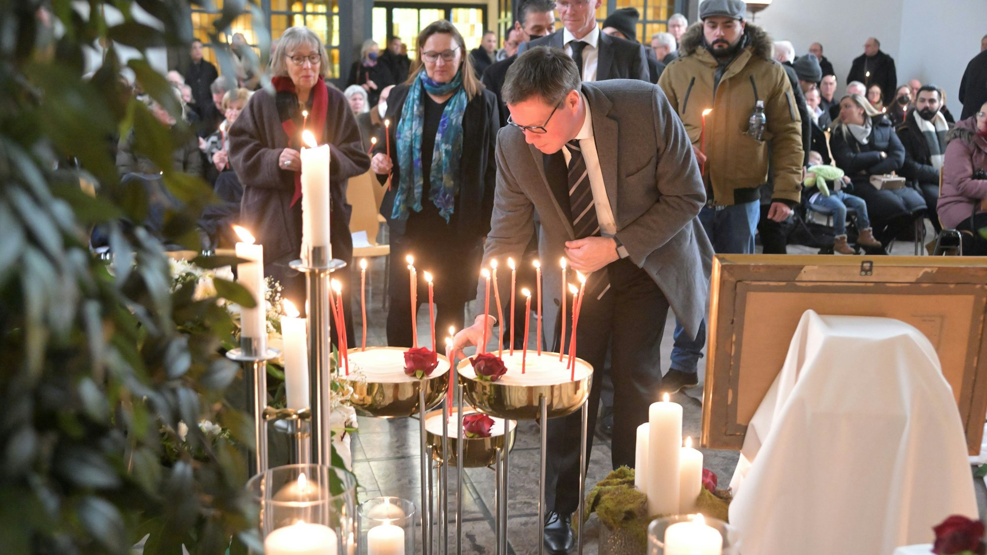 Landrat Stephan Santelmann zündet eine Kerze in der Trauerhalle an.