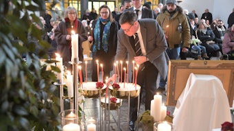 Landrat Stephan Santelmann zündet eine Kerze in der Trauerhalle an.