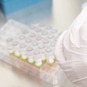 Eine Forscherin untersucht PCR-Test auf das Coronavirus. Die Covid-Variante JN.1, auch Pirola genannt, ist derzeit in Deutschland am verbreitetsten und tritt teilweise mit neuen Symptomen auf.