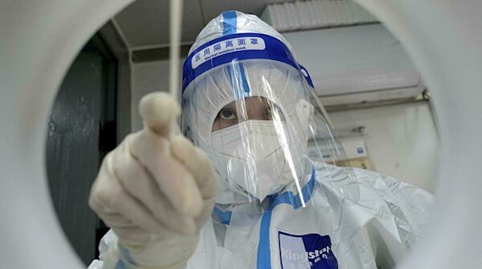 Ein medizinischer Mitarbeiter in Schutzkleidung führt einen PCR-Test zum Nachweis des Coronavirus durch.
