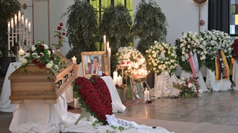 Viele Blumenkränze stehen am Sarg und dem Foto von Philomena Franz.