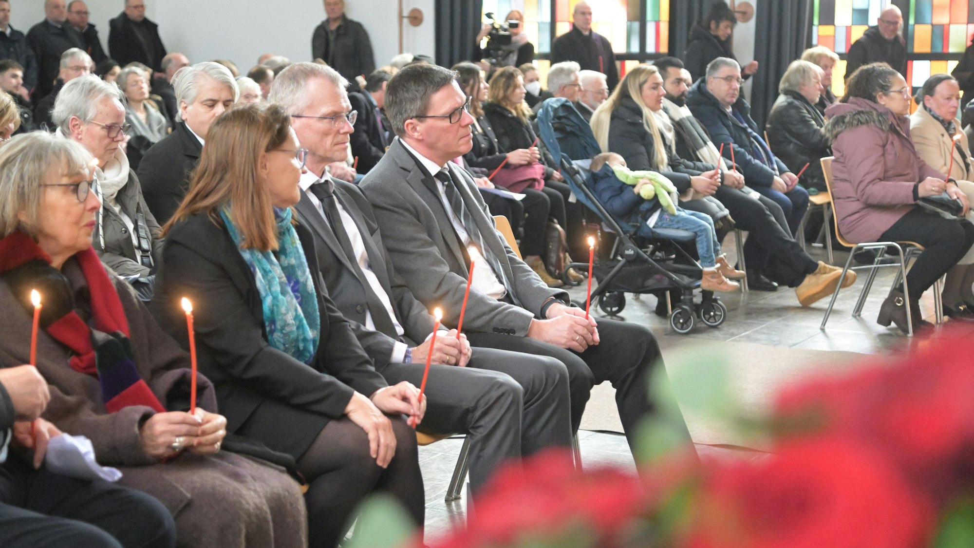 Landrat Stephan Santelmann und Bergisch Gladbachs Bürgermeister Frank Stein sitzen in der Trauergemeinde auf der Beerdigung von Philomena Franz.