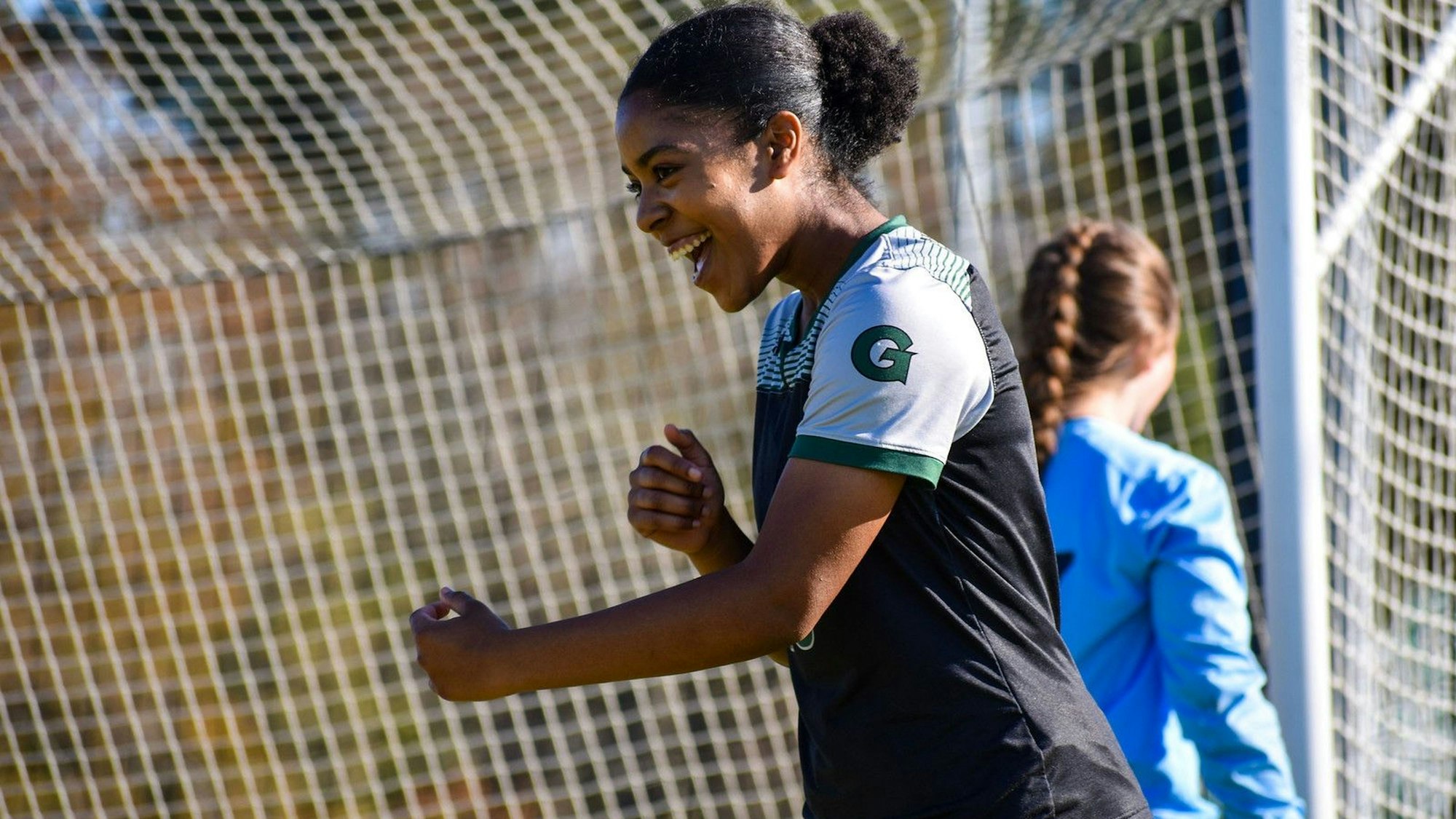 Die Fußballerin Zahra Fepessi aus Zülpich-Schwerfen steht auf einem Fußballplatz und freut sich