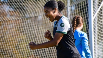 Die Fußballerin Zahra Fepessi aus Zülpich-Schwerfen steht auf einem Fußballplatz und freut sich