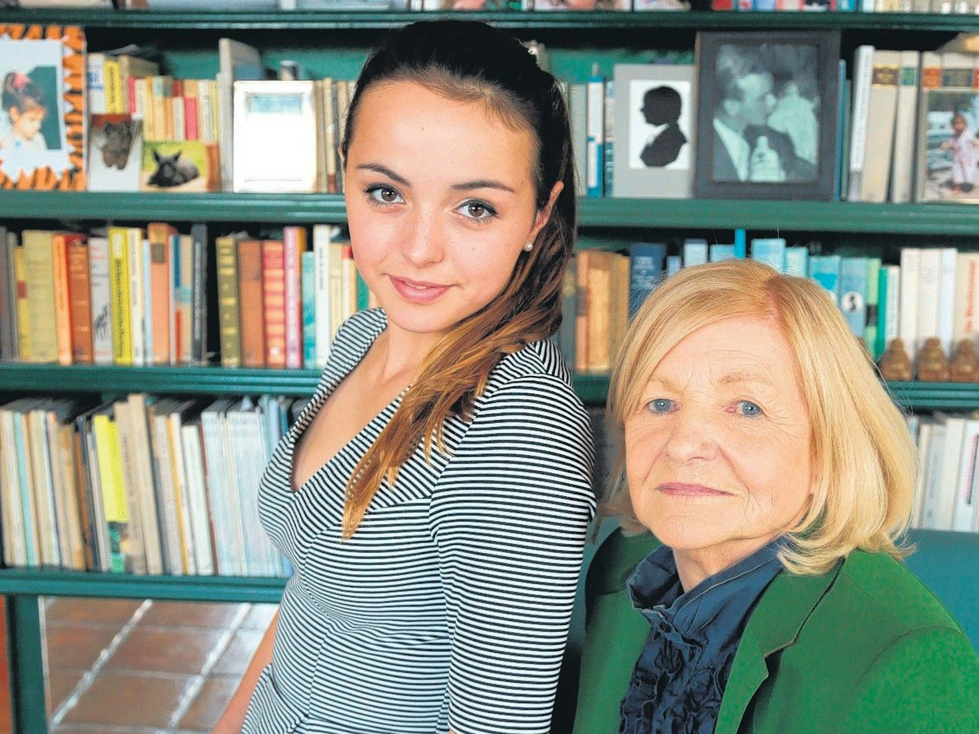 Enkelin Louise sitzt auf dem Schoß von Tina Farina. Im Hintergrund steht ein Bücherregal voller Bücher und Bilder.