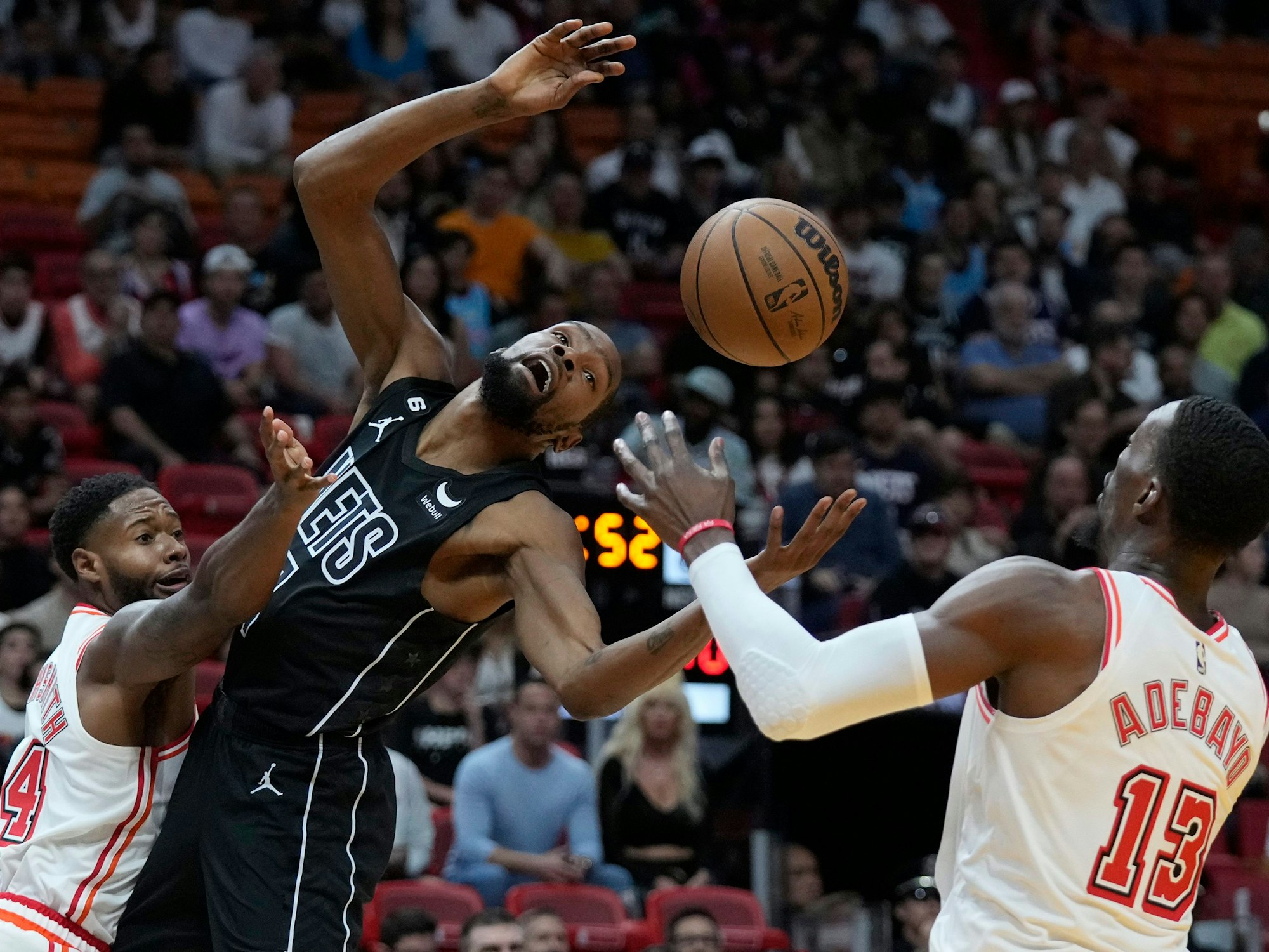 Miami Heat gegen Brooklyn Nets: Haywood Highsmith (l) wehrt den Ball von Brooklyn Nets Stürmer Kevin Durant (M) ab, Center Bam Adebayo (13) ist rechts in Aktion.