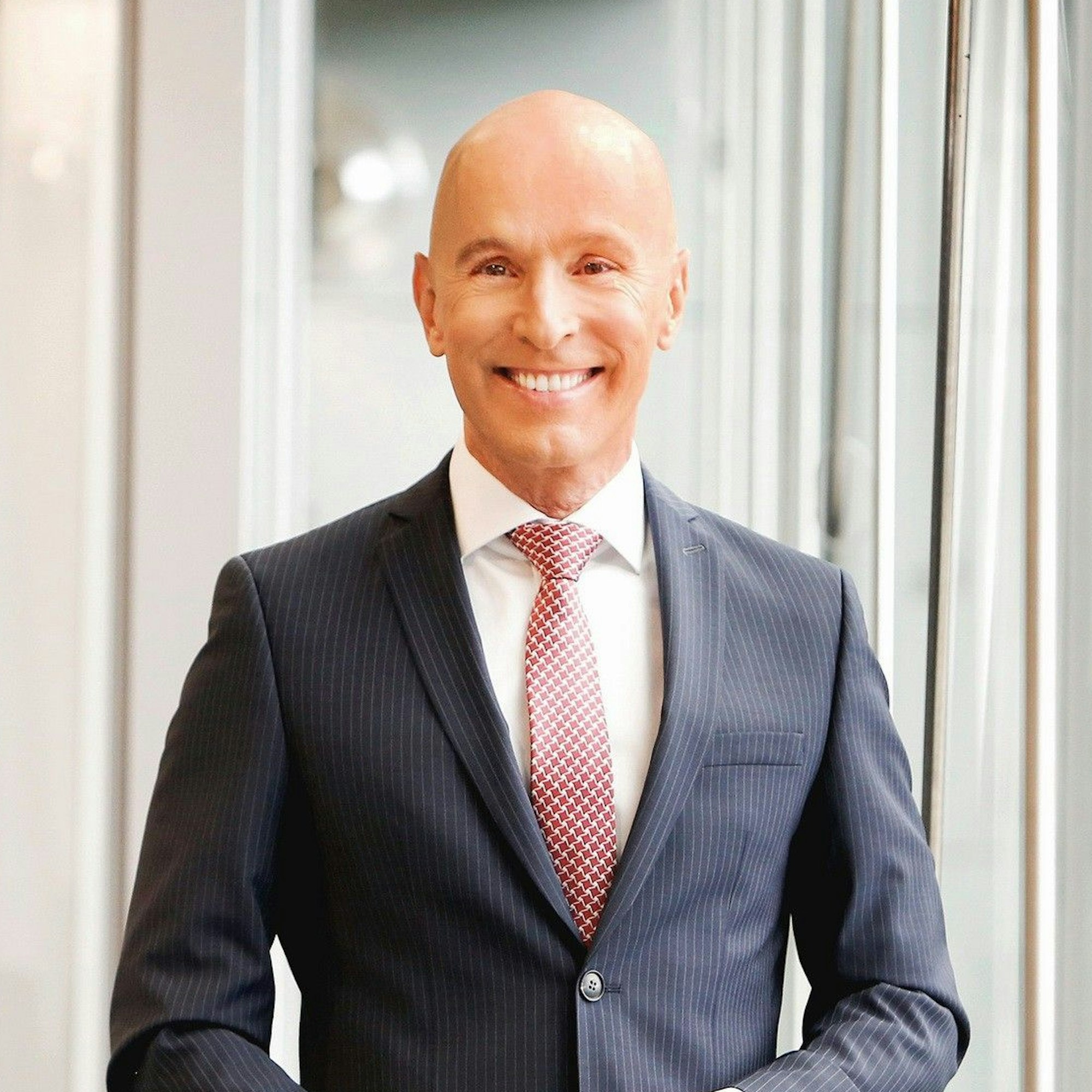 Ein Porträtfoto des RTL-Adelsexperten Michael Begasse. Er lächelt in die Kamera und trägt einen schwaren Anzug mit Nadelstreifen.