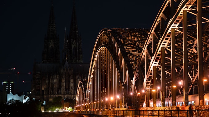 Unbeleuchtet ist der Kölner Dom nach 23 Uhr. Im Vordergrund die Hohenzollernbrücke.