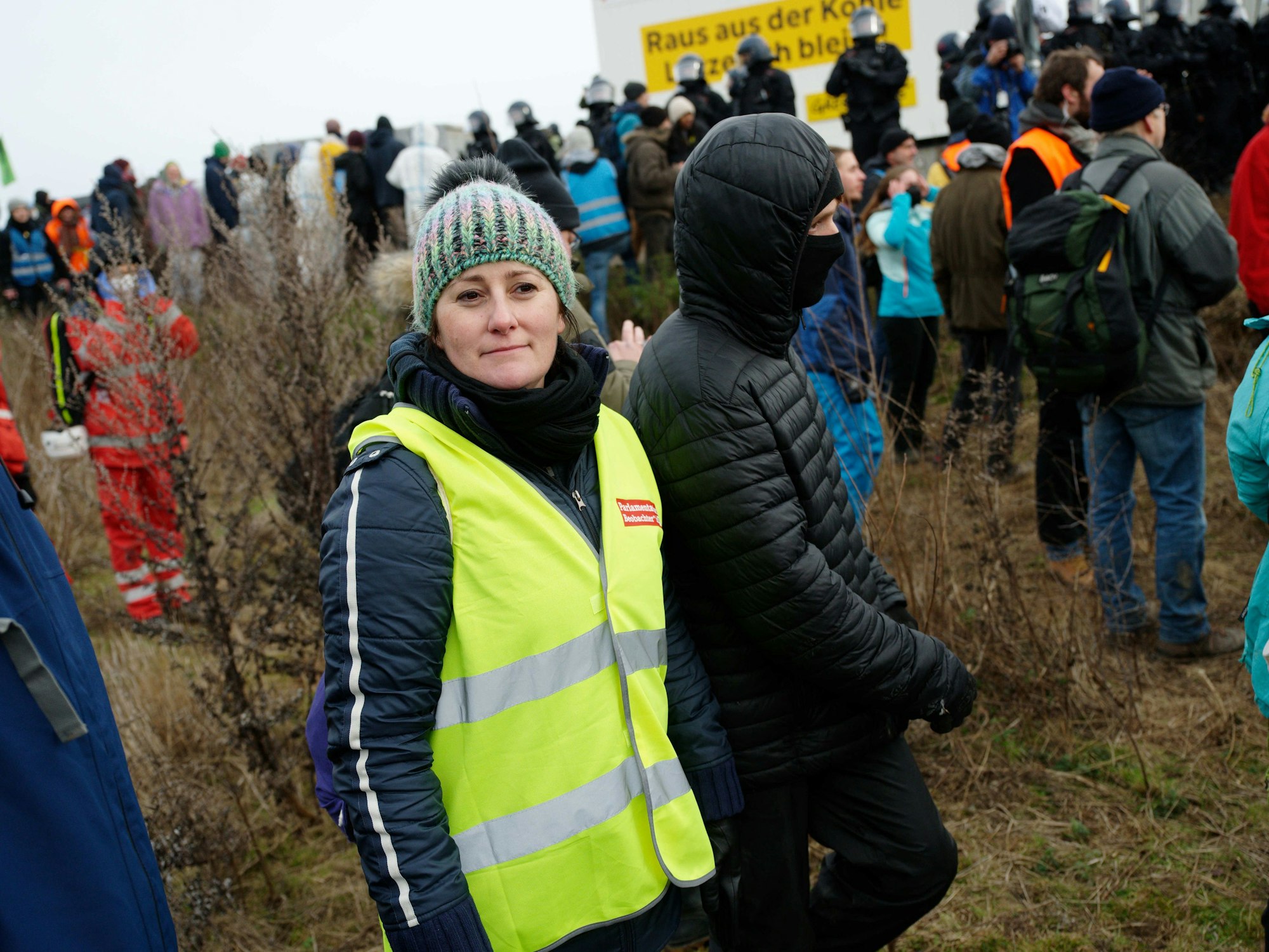 Janine Wissler, Vorsitzende der Partei Die Linke, beobachtet das Geschehen in Lützerath. Sie trägt eine gelbe Warnweste.