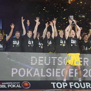 Die Spieler von Alba Berlin jubeln mit dem BBL-Pokal.