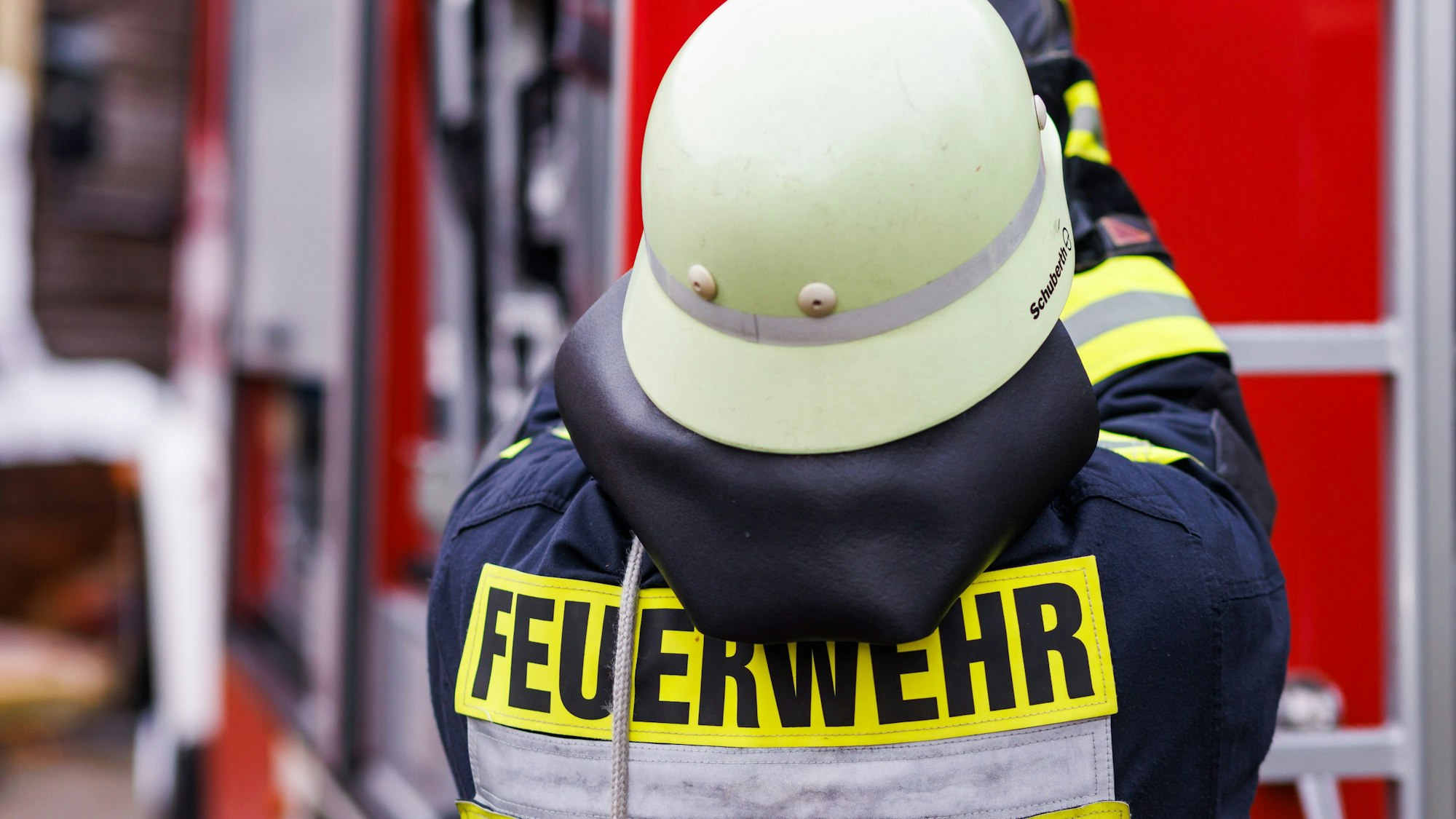 Ein Feuerwehrmann holt während einer Einsatzübung einer Freiwilligen Feuerwehr eine Leiter vom Dach eines Einsatzfahrzeugs. (Symbolbild)