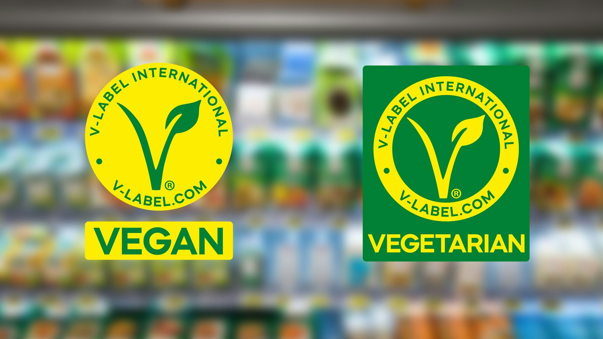 Die neuen Logos der Organisation V-Label sind vor einem verschwommenen Supermarkt-Regal zu sehen. Das eine Logo soll auf veganen, das andere auf vegetarischen Produkten zu sehen sein.