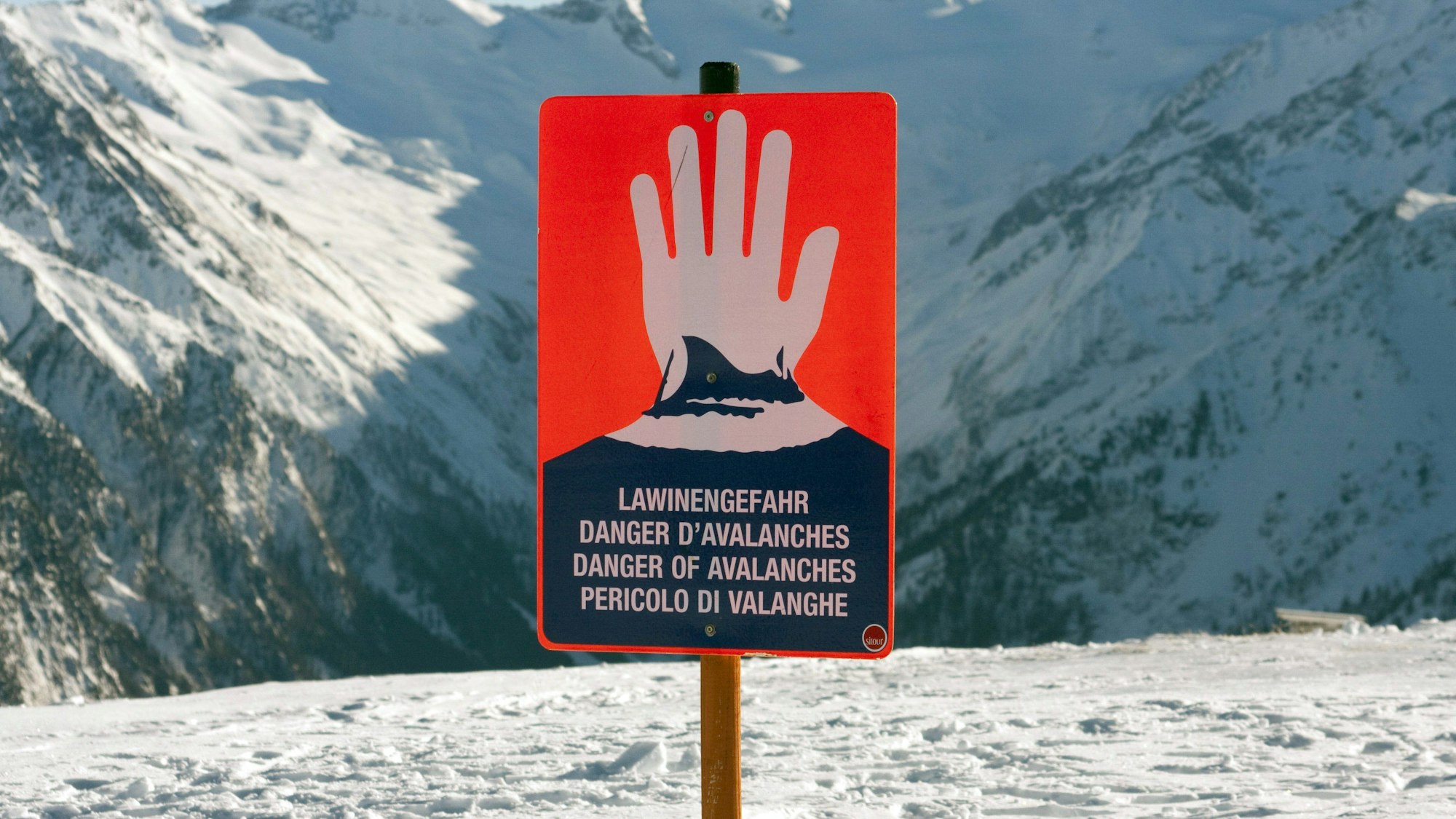 Ein Schild warnt im Skigebiet auf dem Wildkogel in den Alpen vor Lawinengefahr.