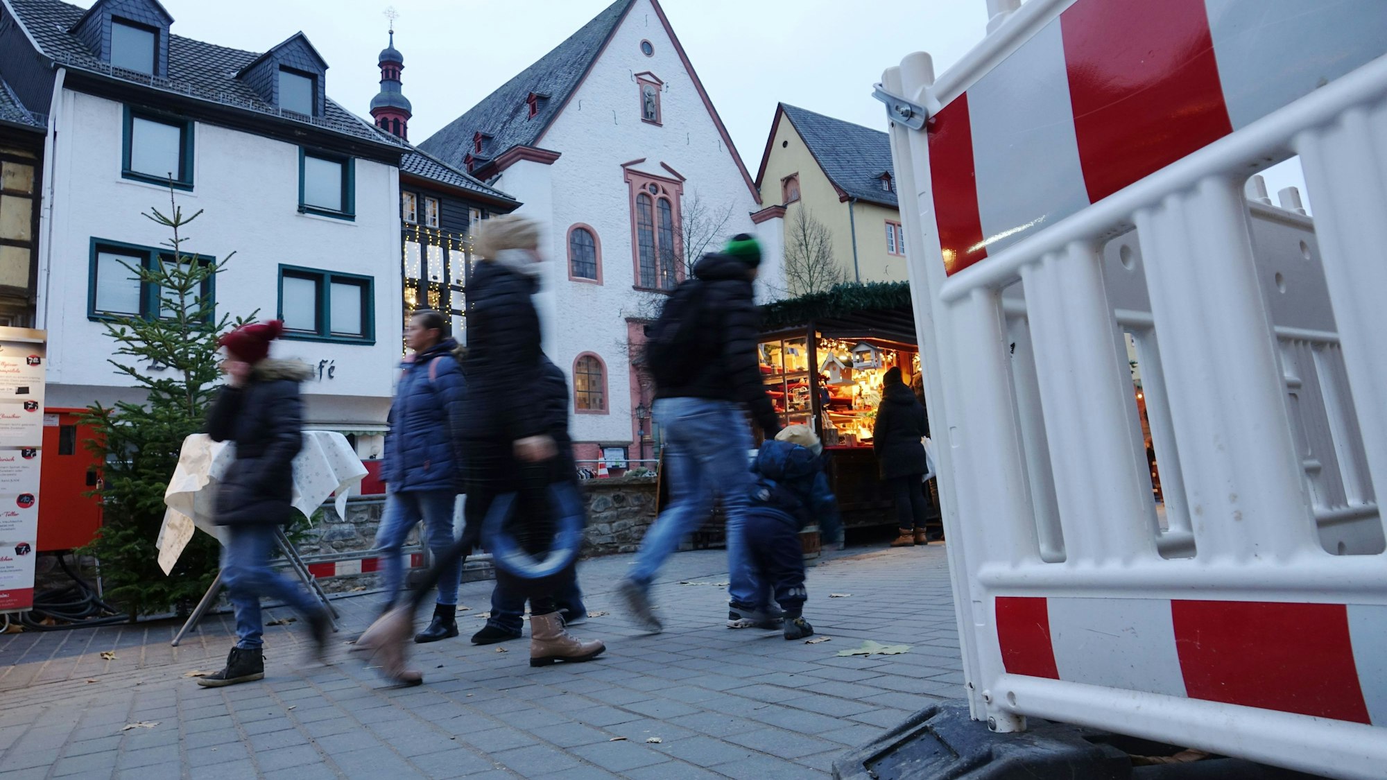 Menschen gehen an einer Absperrbake in Bad Münstereifel vorbei.