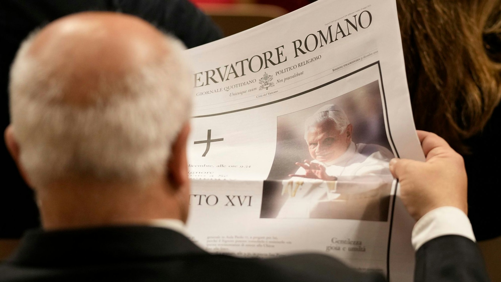 Ein Besucher liest im Petersdom die Nachricht vom Tod des emeritierten Papstes Benedikt XVI. in der Vatikanzeitung L'osservatore Romano. Nach einem kritischen Bericht über Joseph Ratzinger ermittelt die Polizei nun gegen das Portal „queer.de“. (Archivbild)
