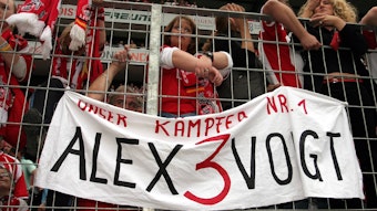 Die Fans des 1. FC Köln präsentieren ein Plakat mit der Aufschrift "Unser Kämpfer Nr. 1 - Alex3Voigt".