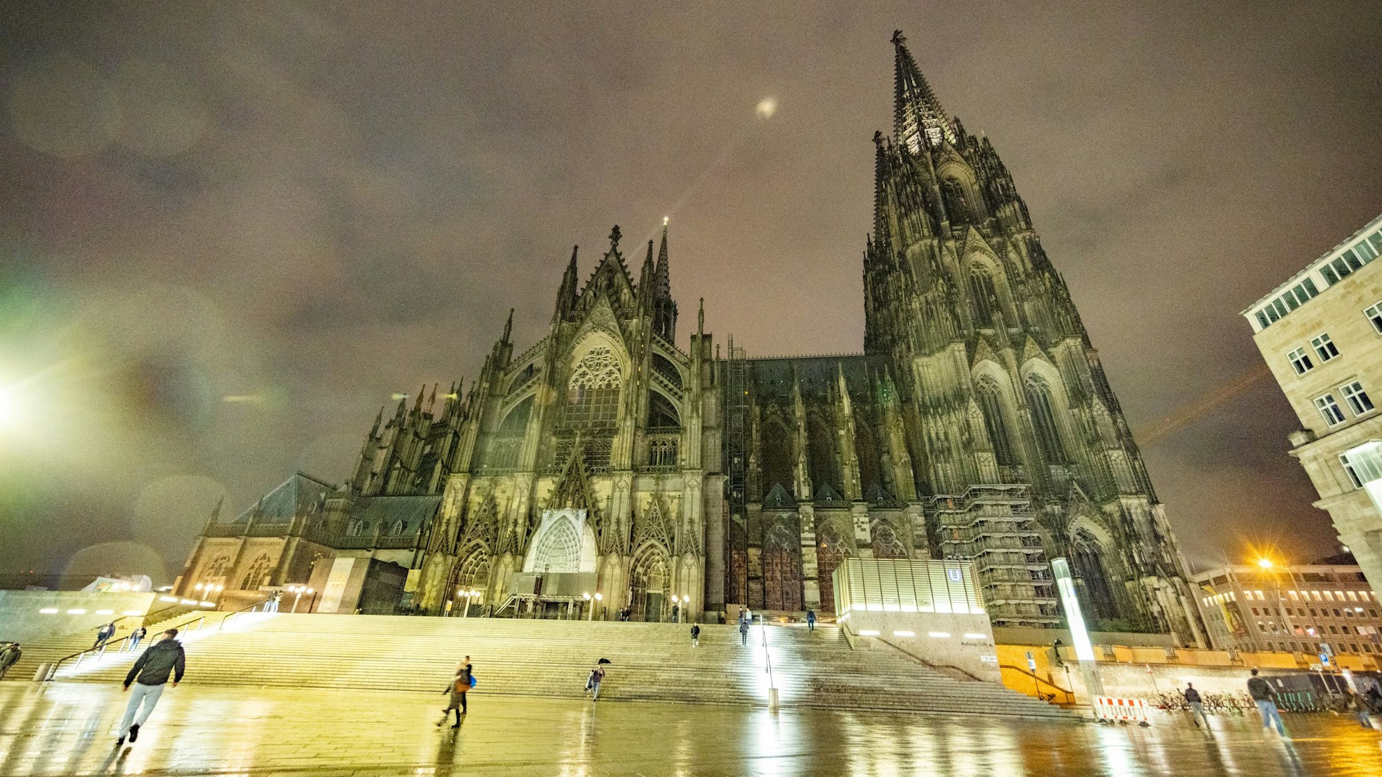 Der Kölner Dom voll angeleuchtet, bei Dämmerung und aus der Froschperspektive.