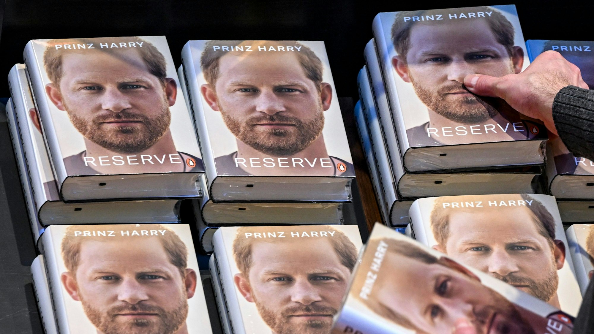 Einige Exemplare der Biografie von Prinz Harry liegen zum Verkauf bereit. Auf dem Umschlag ist ein Porträt von Prinz Harry zu sehen, darunter steht der deutsche Titel des Buches: "Reserve".