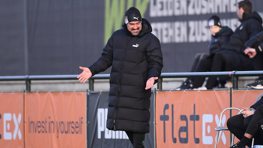 Daniel Farke steht im Testspiel von Borussia Mönchengladbach gegen den VfB Oldenburg am Spielfeldrand und gestikuliert. Der Trainer streckt seine Arme heraus und macht eine fragende Geste zu seinen Assistenten.