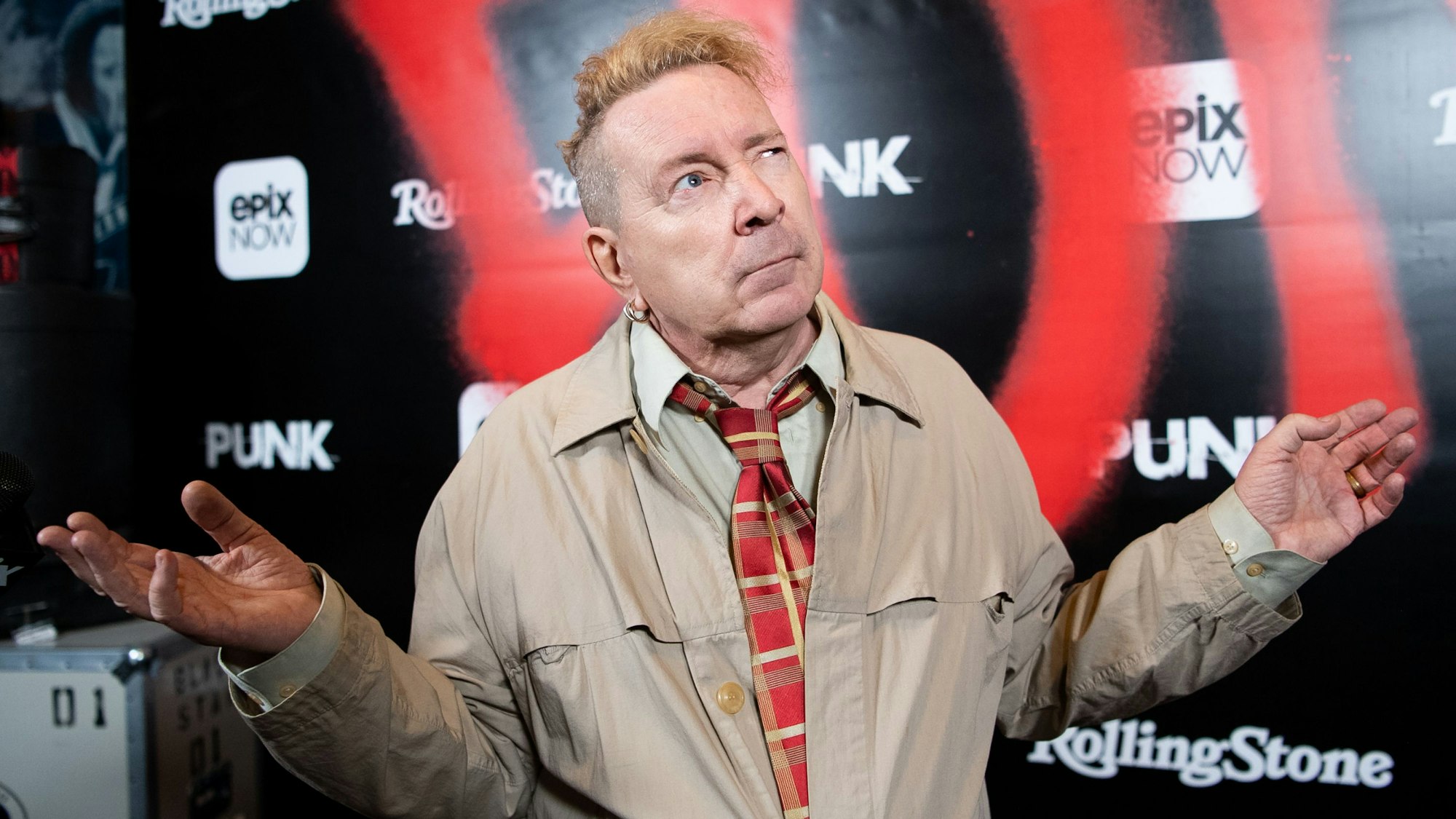 John Lydon alias Johnny Rotten, Sänger von Public Image Ltd, breitet die Arme aus und blickt fragend nach oben.