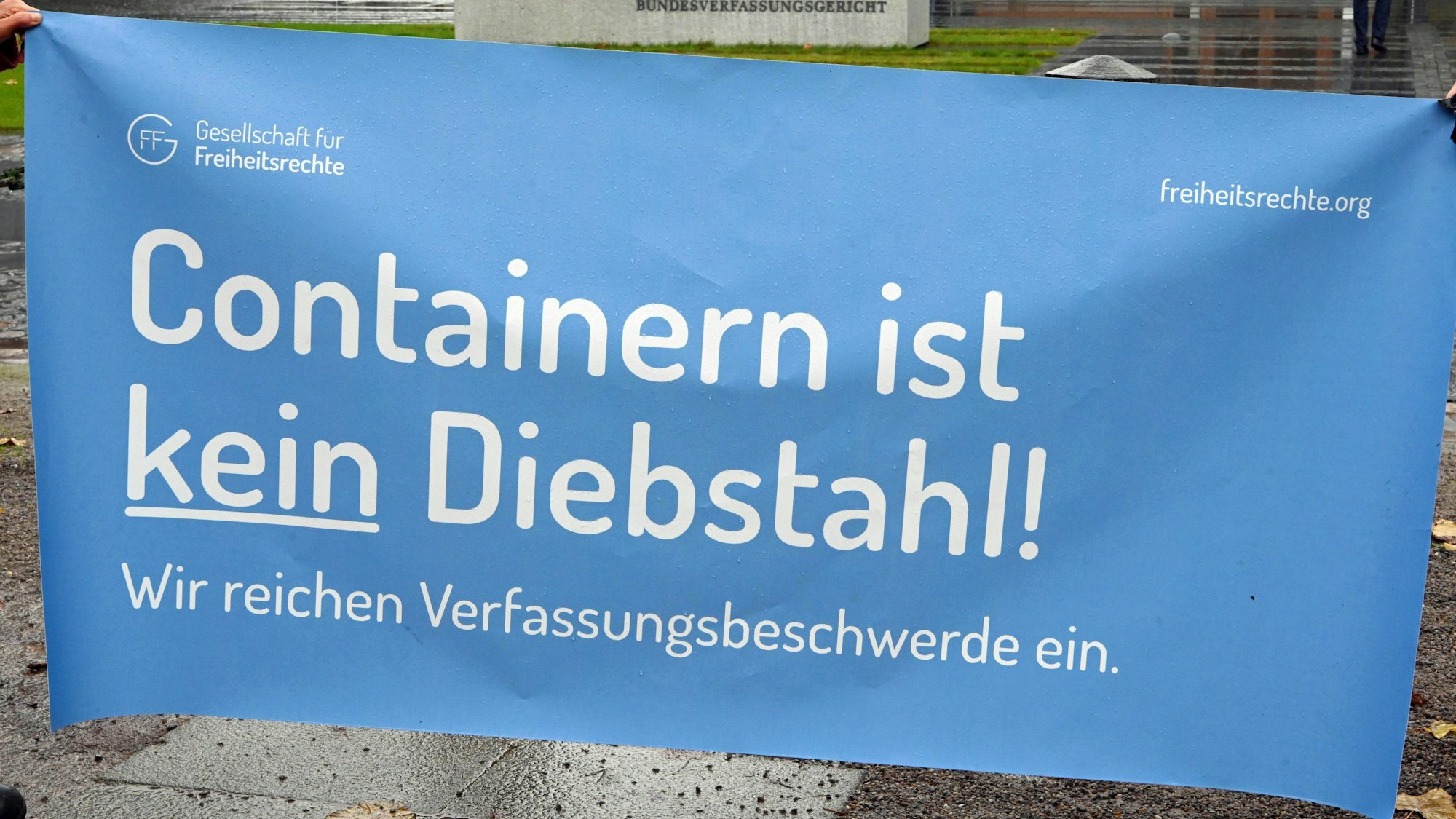 Karlsruhe: Vor dem Bundesverfassungsgericht wird ein ein Transparent gehalten auf dem steht ·Containern ist kein Diebstahl.