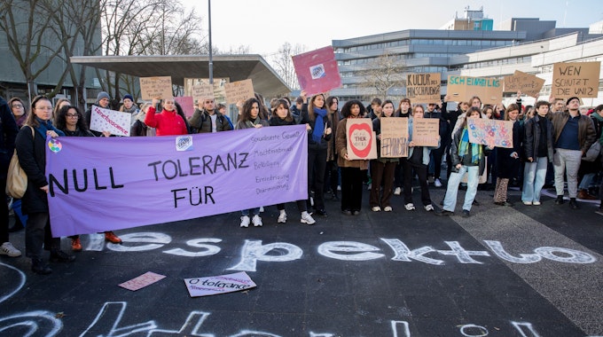 Etwa 250 Menschen demonstrieren auf dem Albertus-Magnus-Platz an der Uni Köln gegen sexualisierte Gewalt und halten Plakate in die Höhe.




