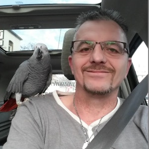 Ingo Stromberg mit Papagei Freddy: Der Vogel sitzt auf der Schulter.