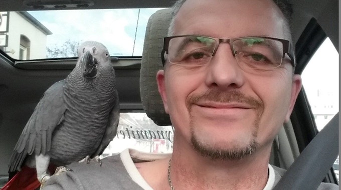 Ingo Stromberg mit Papagei Freddy: Der Vogel sitzt auf der Schulter.